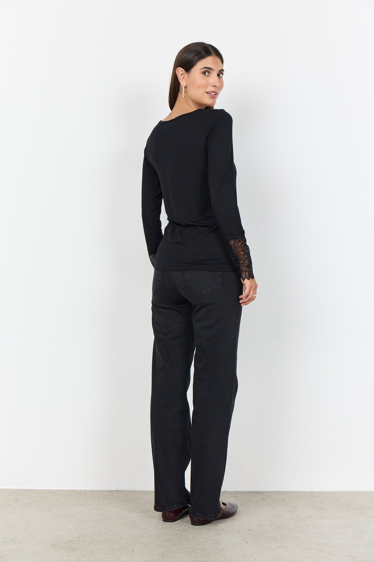 Zwarte top met lange mouwen en kantdetail op onderarm