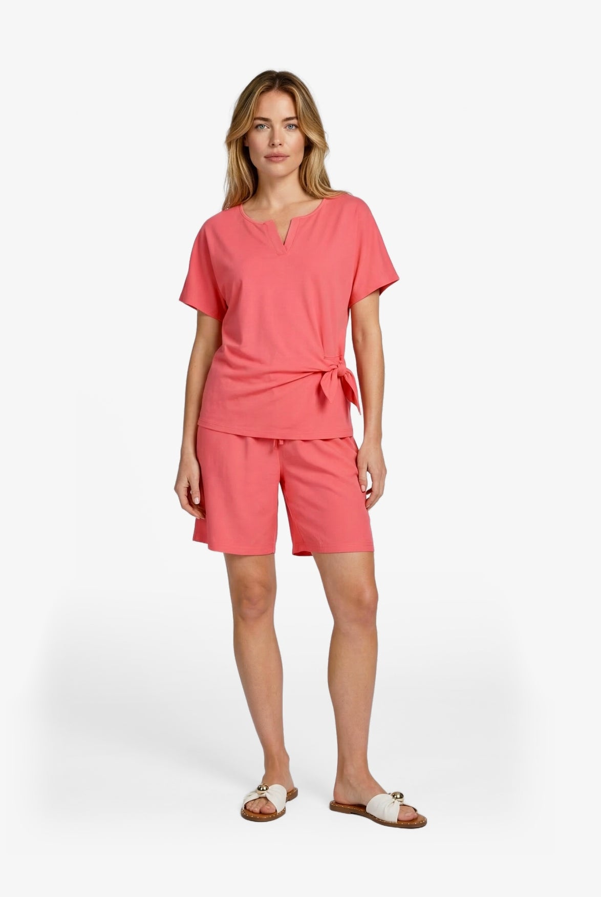Roze top met V-hals en korte mouwen; strikdetail bij de taille.
