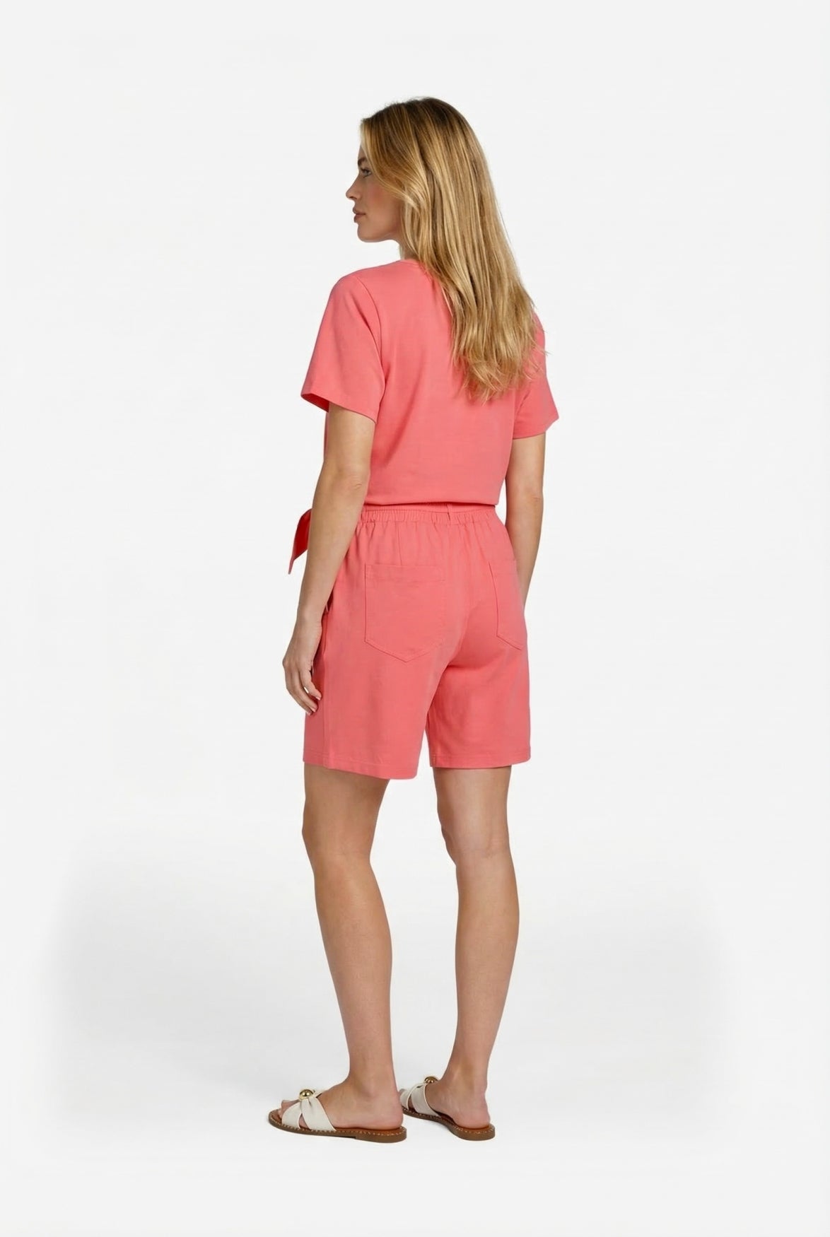Roze top met lage hals en strik bij de taille, achterkant in zijaanzicht.