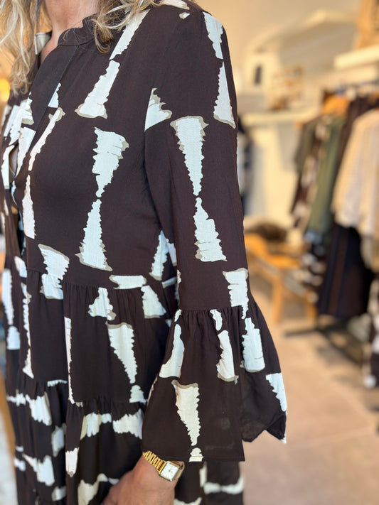 Jurk detail: lange mouw met plooien, bruin met witte abstracte vlakken