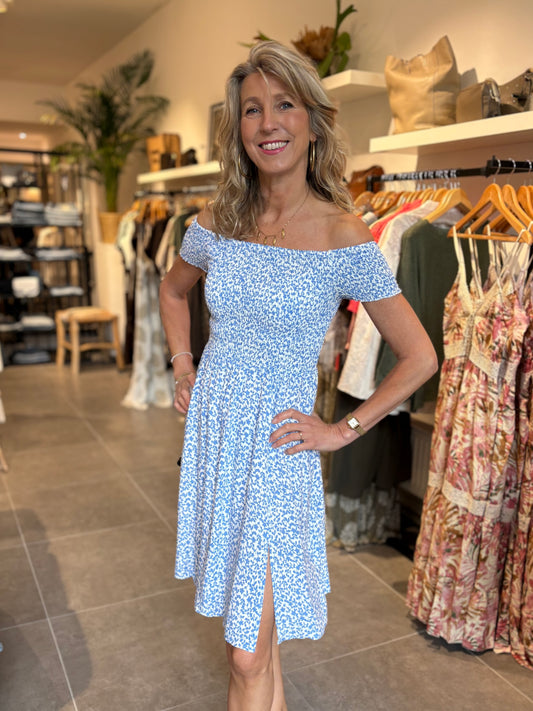 Blauwe off-shoulder jurk met klein bloemenpatroon en geplooide rok