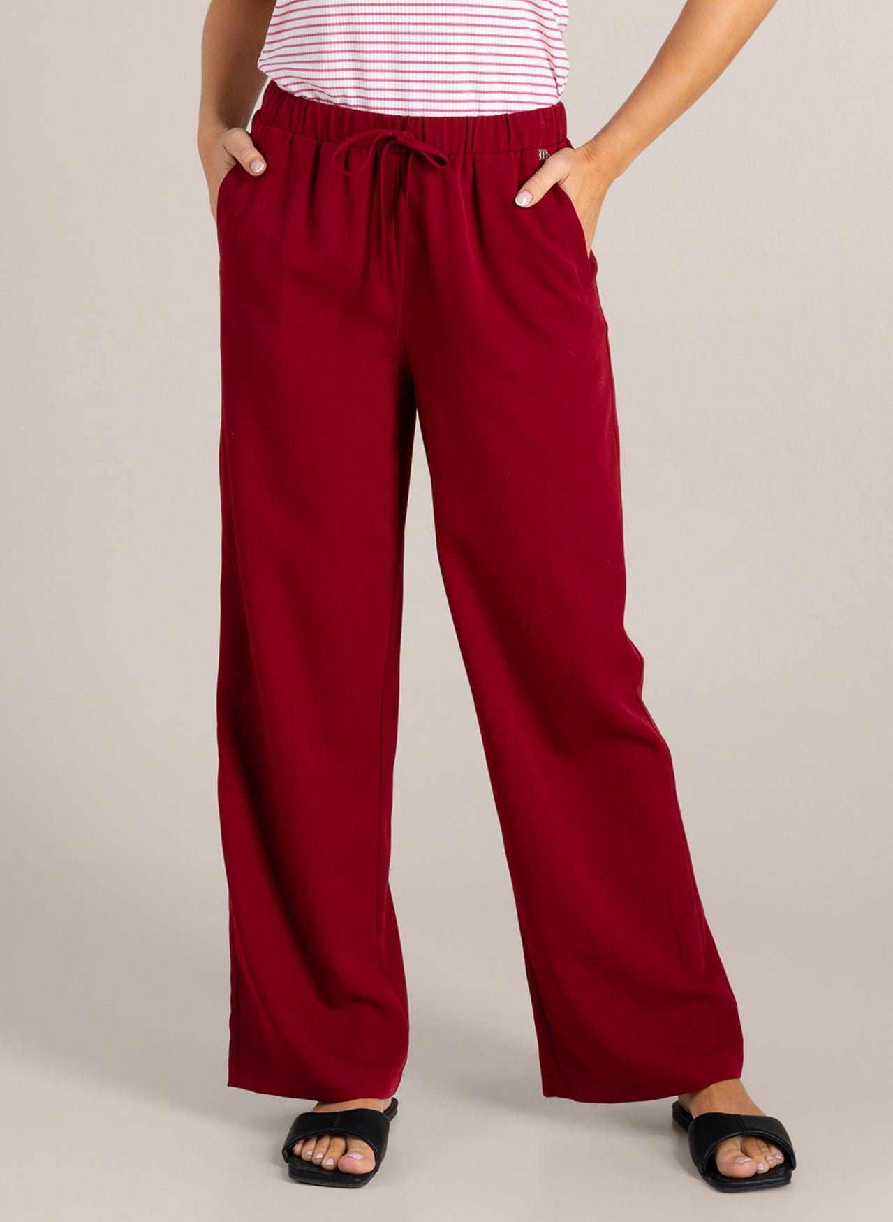 Rode wijde broek met aantrekkoord in de taille en wijde pijpen.