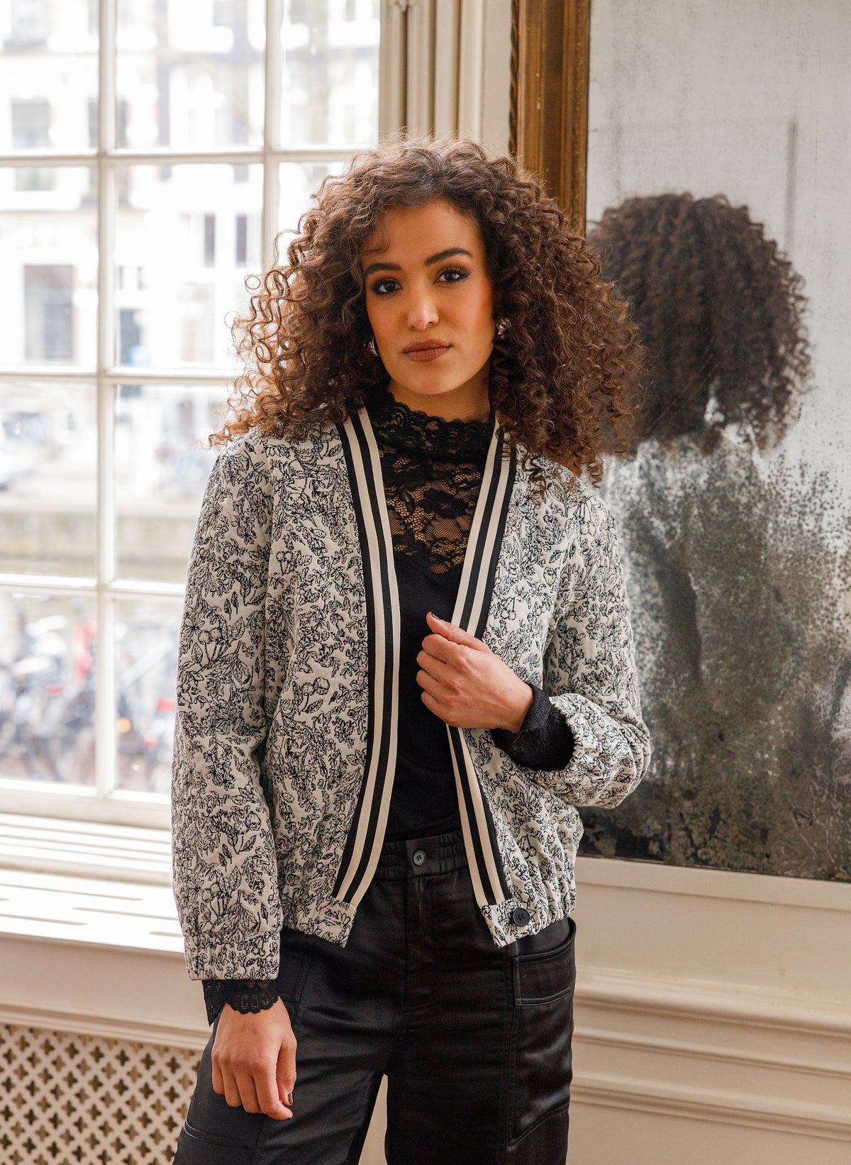 Cropped jasje met V-hals, zwart-wit bloemenprint en biezen met contraststrepen