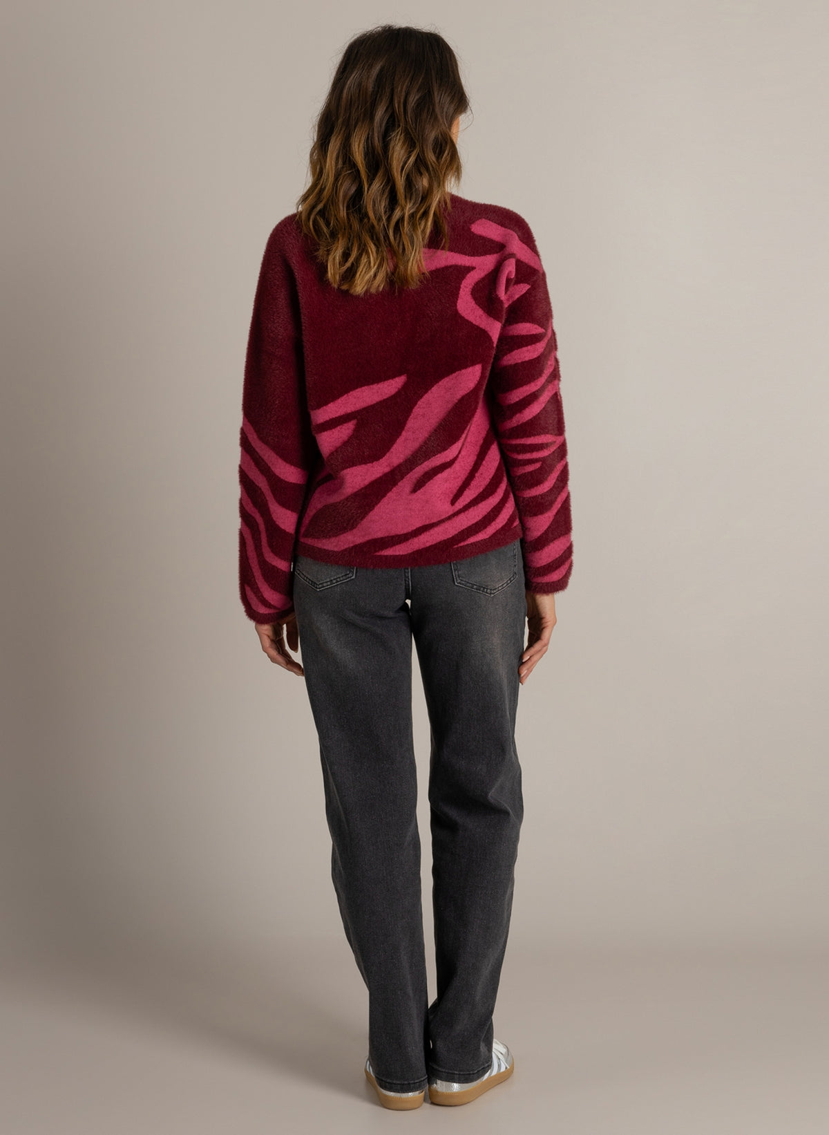 Trui met ronde hals en donkerwijnrode achterzijde met roze abstract patroon en lange mouwen.