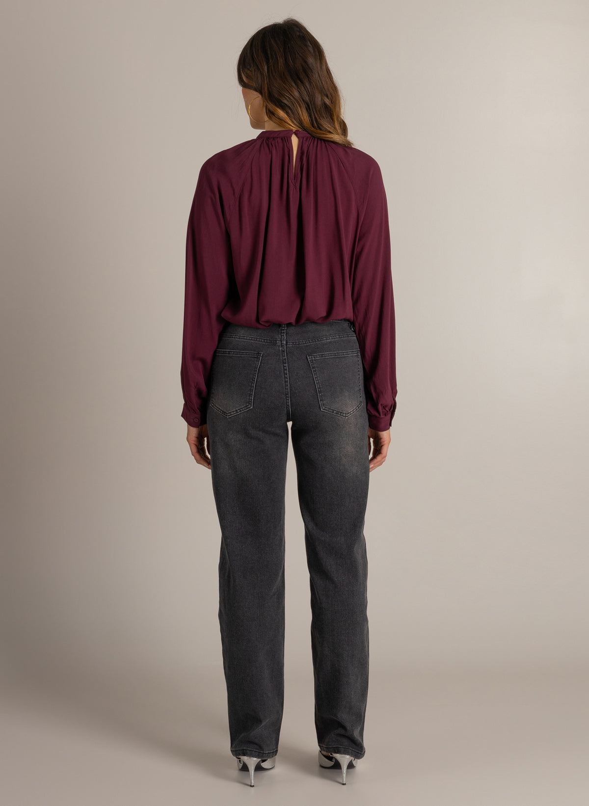 Donkerwijnrode blouse met strikdetails bij hals en lange mouwen; achteraanzicht