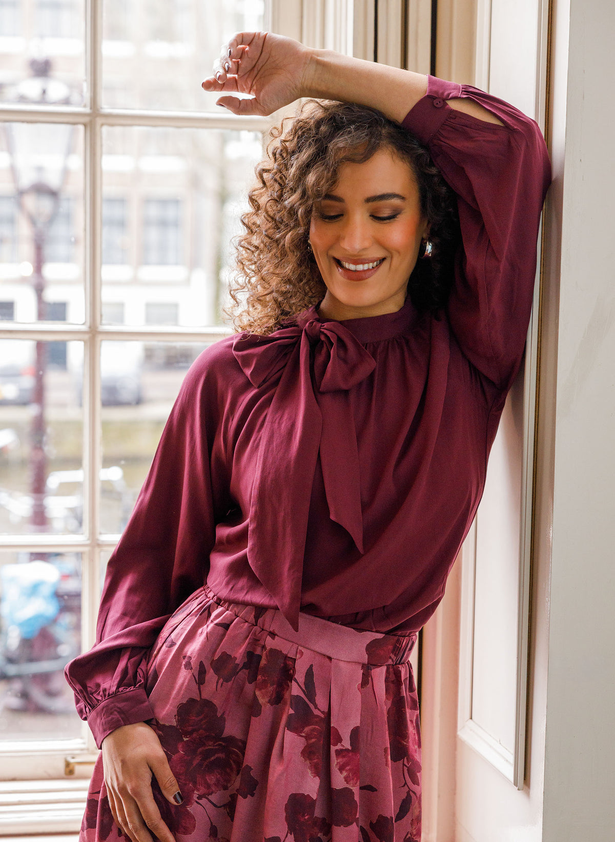 Donkerwijnrode blouse met strik bij de hals en volumineuze ballonmouwen