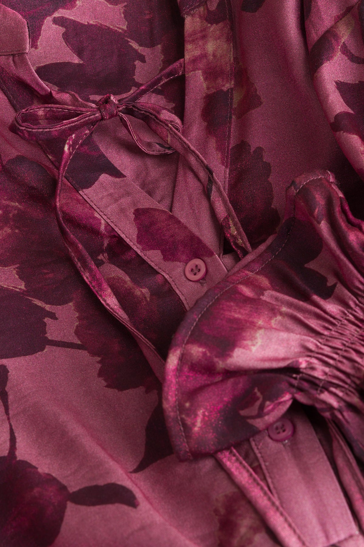 Close-up bloemenprint blouse: strik aan kraag en knopen op de placket