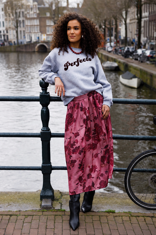 Grijze melange sweater met ronde hals en ‘Perfecto’ opdruk, gedragen met rok