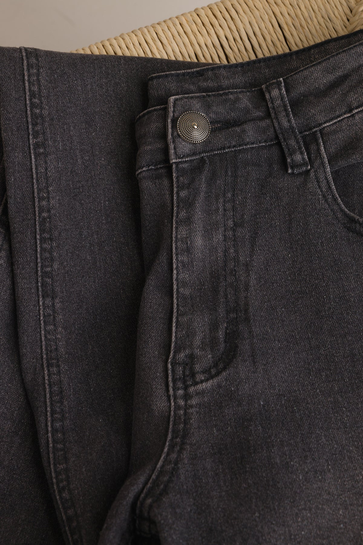 Denim detail: knoopsluiting en riemlus op donkere jeans met voorzak