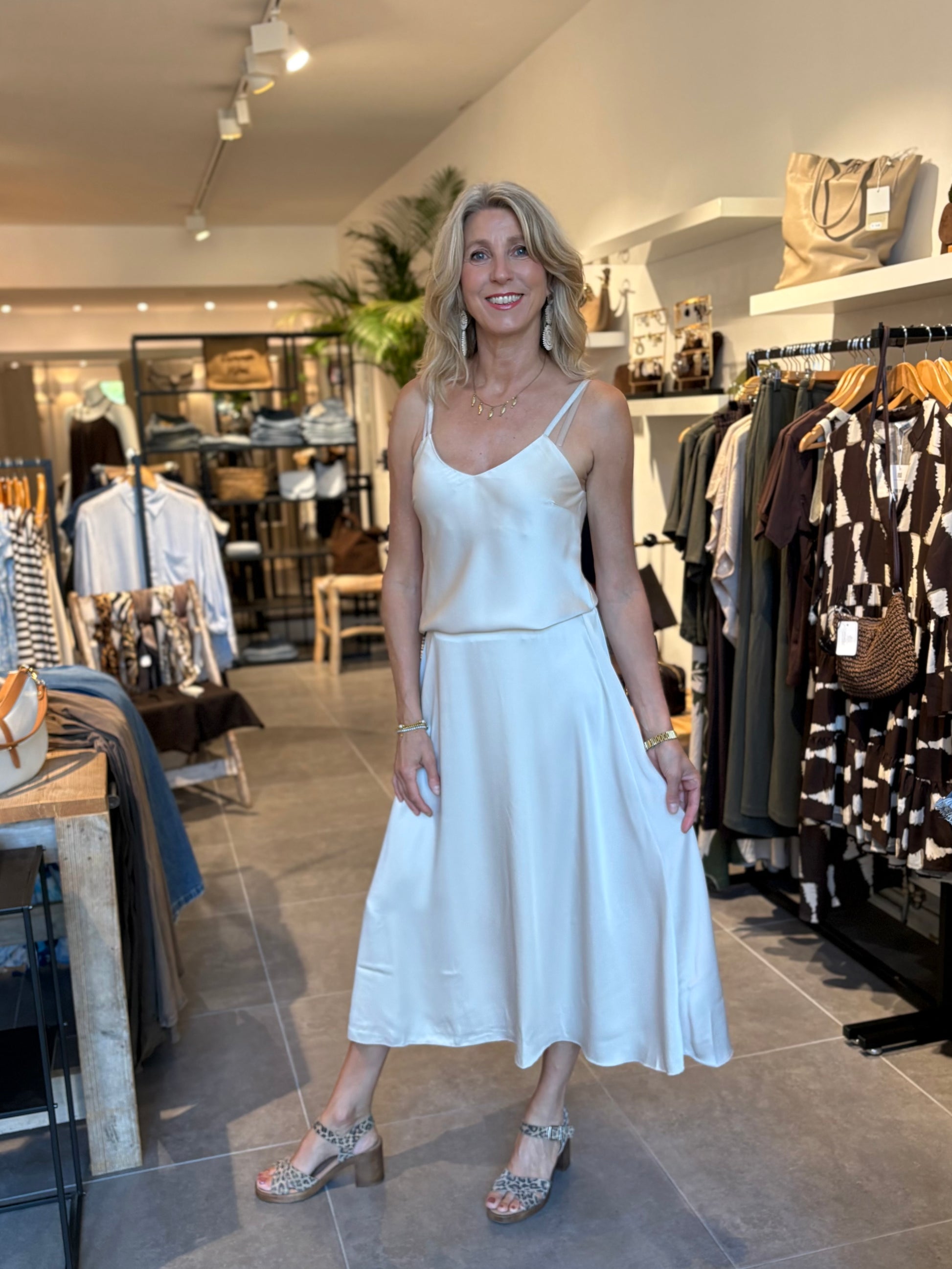 Lichtgekleurde A-lijn rok met smalle bandjes en V-hals, wijdvallende zoom