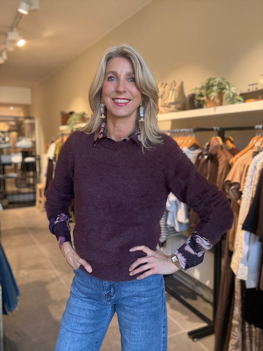 Bordeauxrode fuzzy trui met ronde hals en lange mouwen, gecombineerd met blauwe jeans