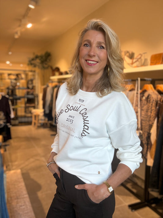 Ecru sweattrui met ronde hals en borstprint, lange mouwen met blauwe tekst