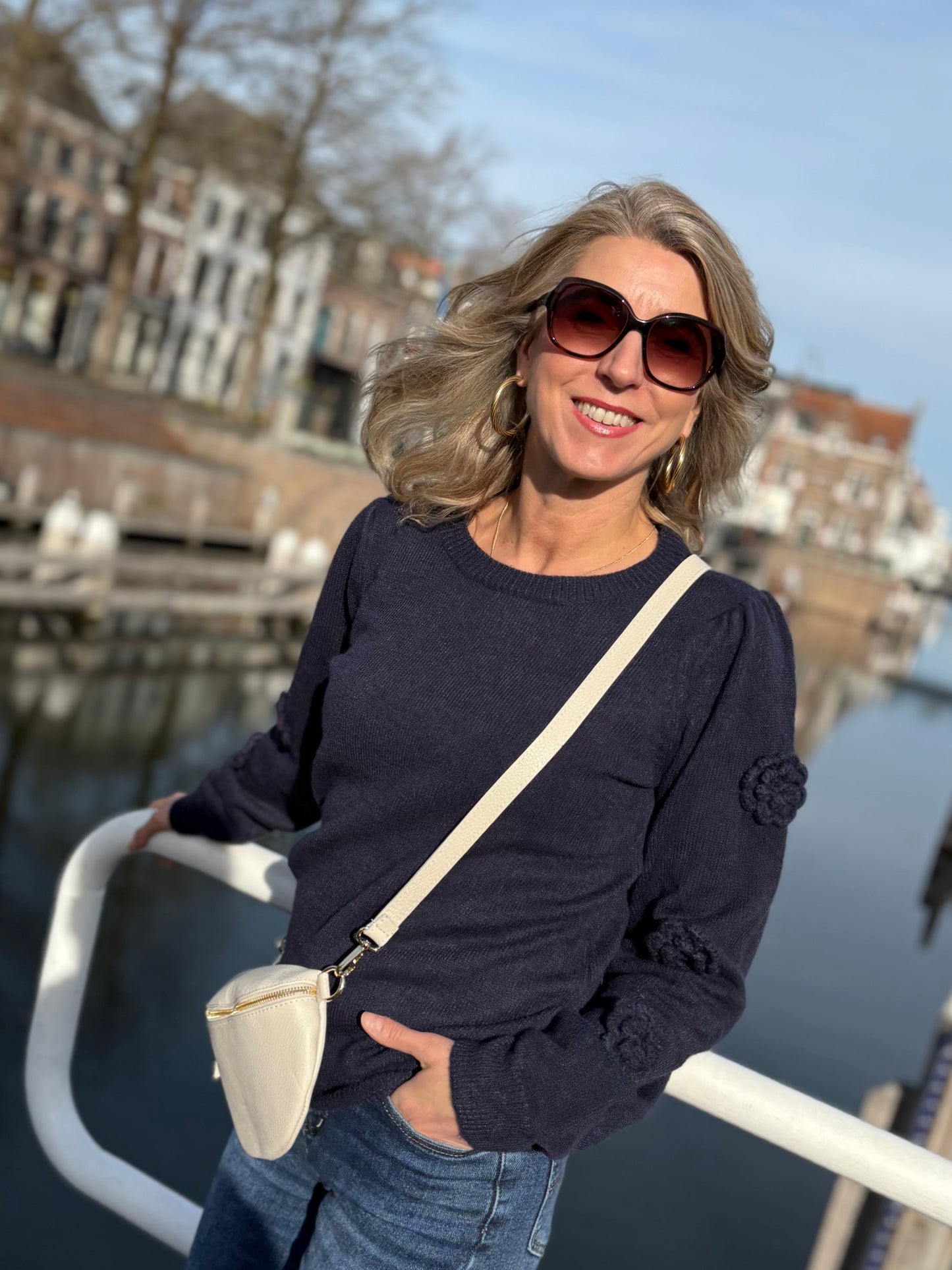 Donkerblauwe trui van C&S met gebreide rozen op de mouwen