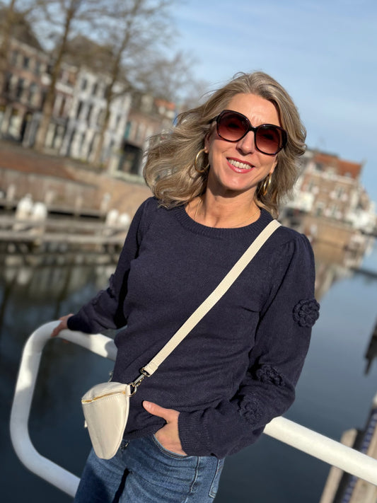 Donkerblauwe trui van C&S met gebreide rozen op de mouwen