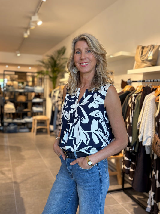 Donkerblauwe mouwloze top met wit bloemenpatroon, getailleerde snit