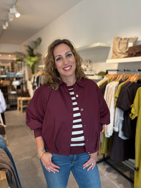 Bordeaux blouse met knoopsluiting, staande kraag en opgestikte manchetten.