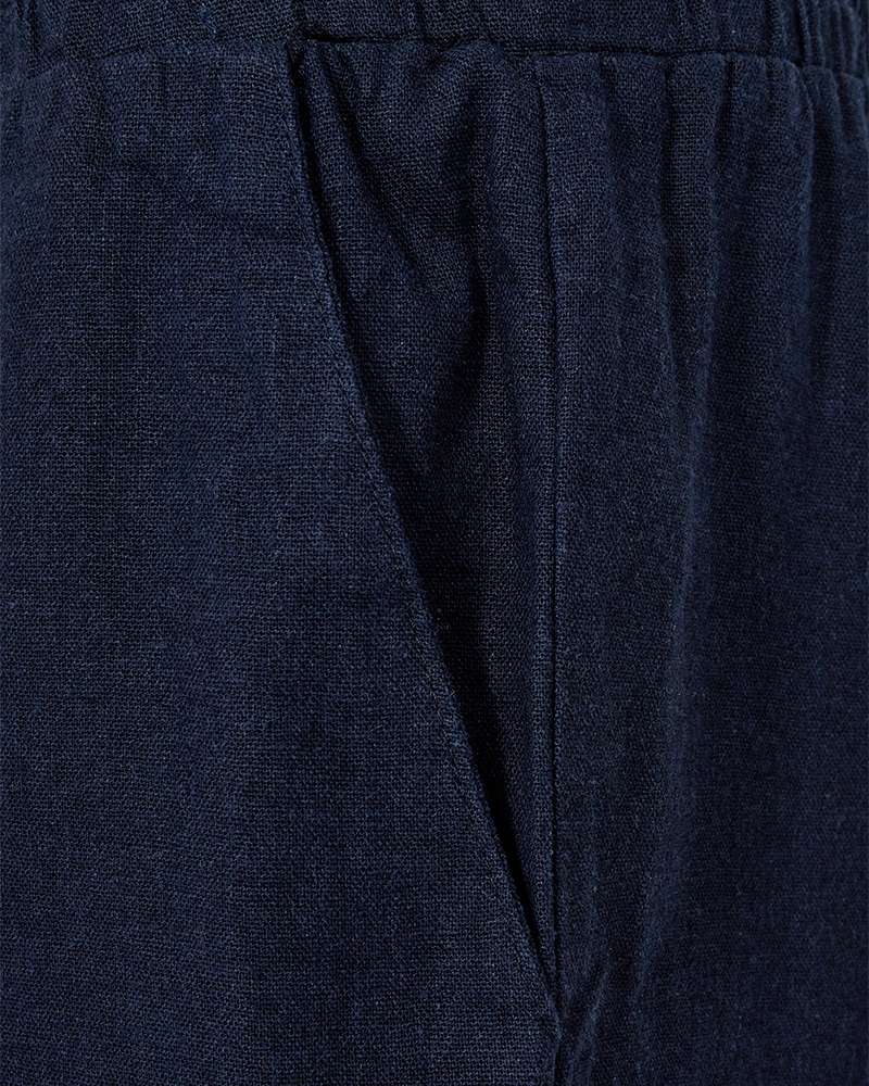 Donkerblauw stofdetail van korte broek met trekkoord en naad