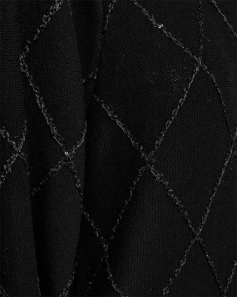 Zwarte trui-detail met ruitvormige stiknaden over stof
